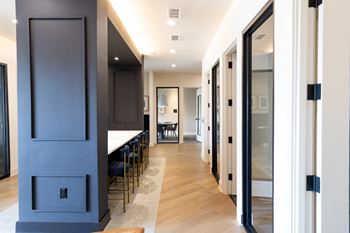 A long hallway with a table and chairs on the left and a glass door on the right at The Crest at South Point Apartments, Davenport , GA, 30253
